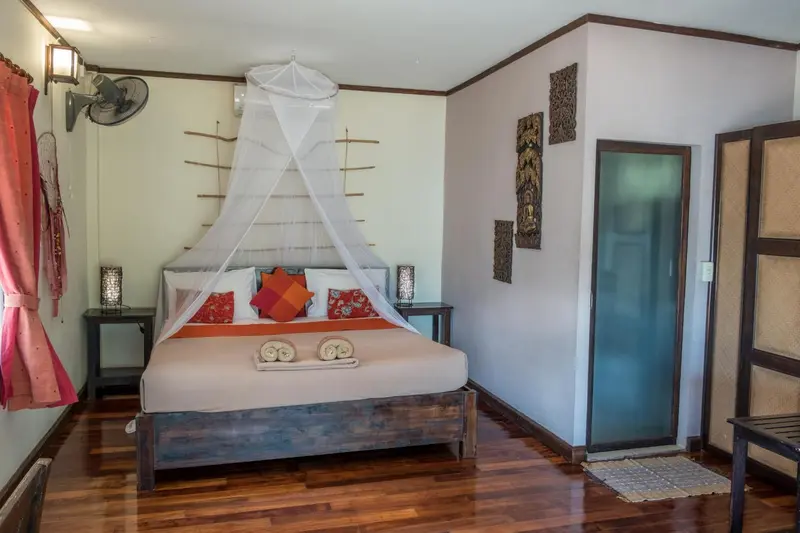 Une chambre lumineuse avec un grand lit à baldaquin et une décoration murale.