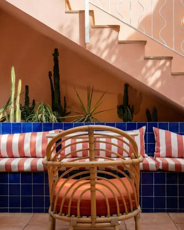 Un espace de détente extérieur avec des sièges en osier et des plantes.