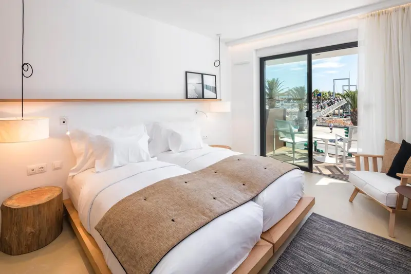 Une chambre lumineuse avec un grand lit et un accès à une terrasse.