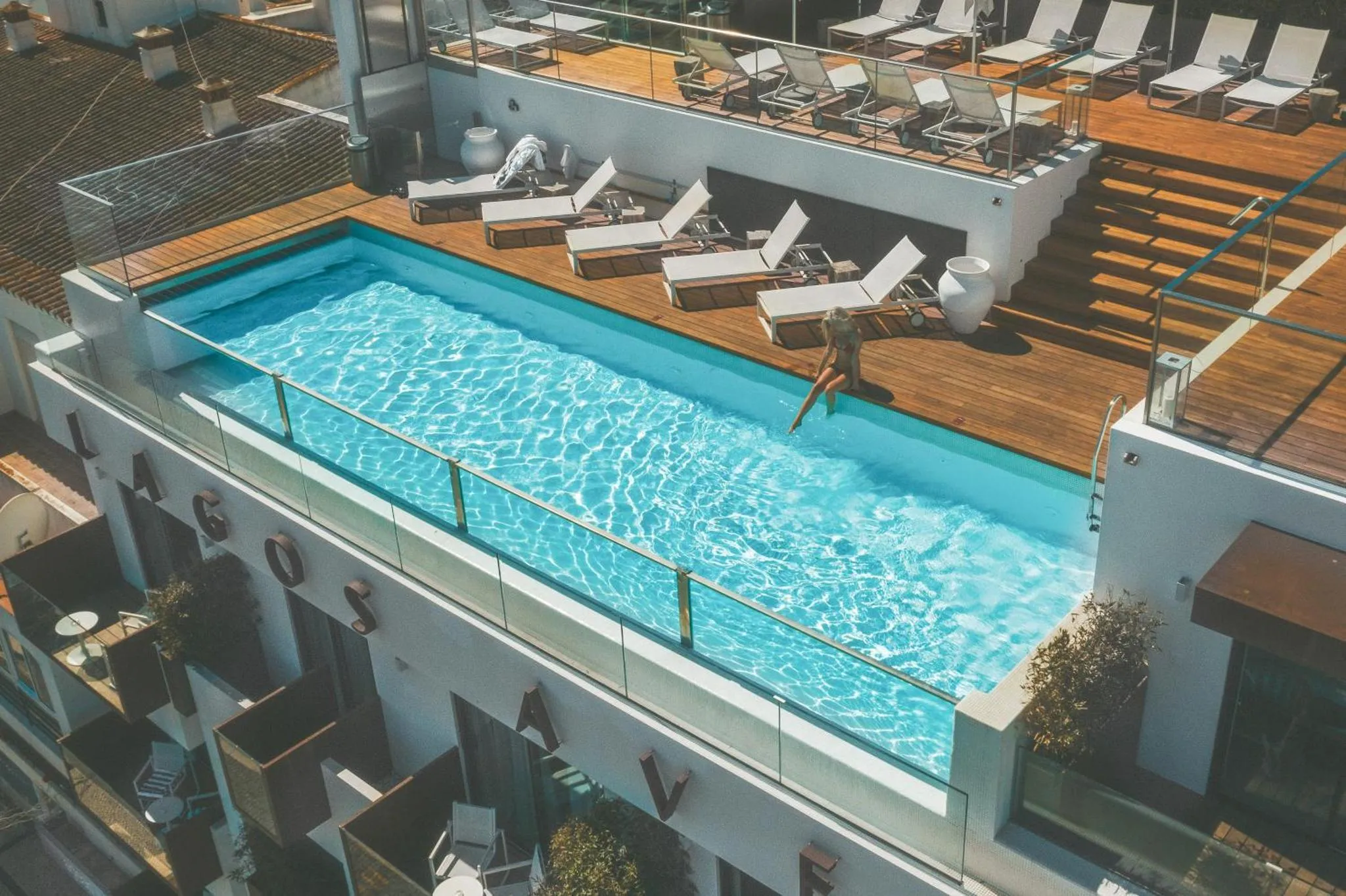 Une piscine rectangulaire sur un toit-terrasse avec des transats.