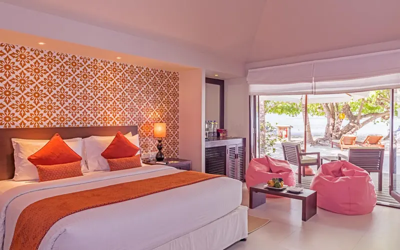 Une chambre lumineuse avec un grand lit et un espace détente.