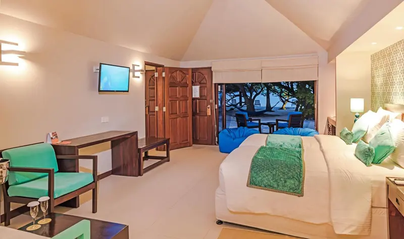Chambre lumineuse avec un lit king-size et un coin salon.