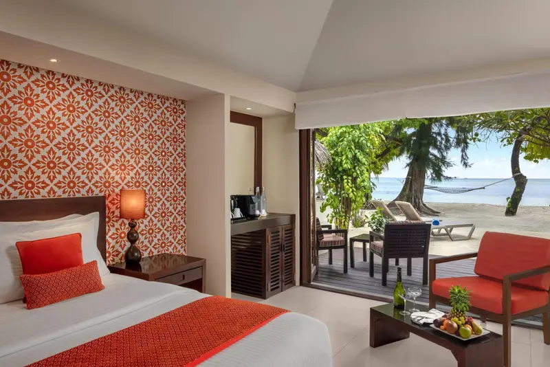 Chambre lumineuse avec un lit et une vue sur la plage.