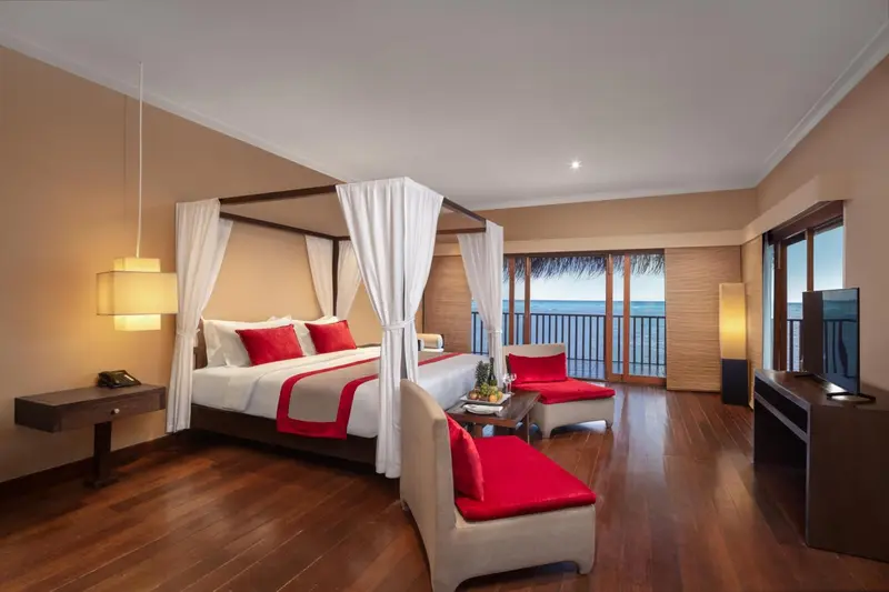 Une chambre spacieuse avec un lit à baldaquin donnant sur l'océan.