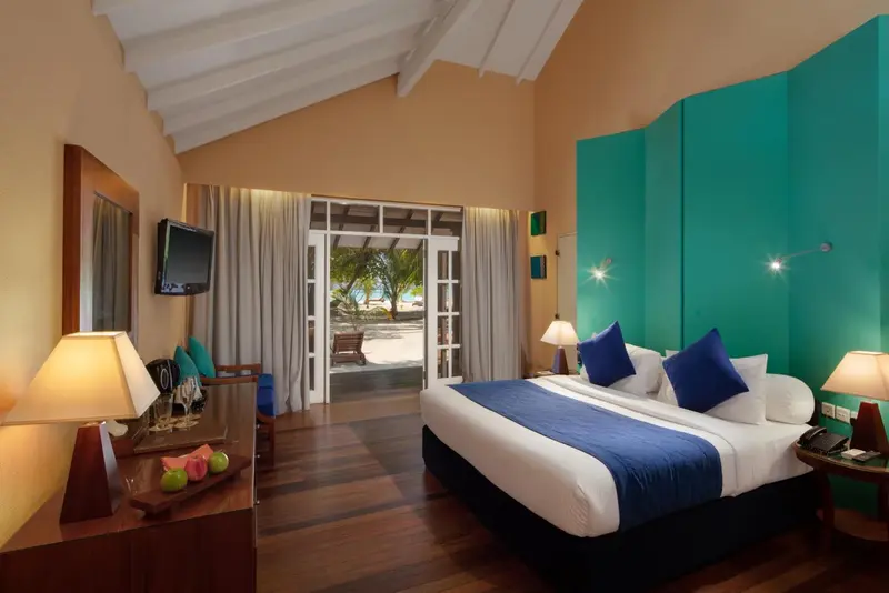 Une chambre lumineuse avec un grand lit et un accès à une terrasse.