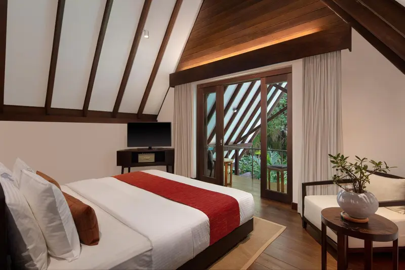 Une chambre lumineuse avec un grand lit et un accès à une terrasse.