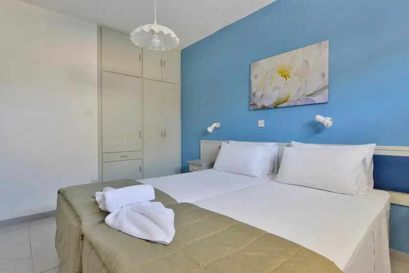 Une chambre lumineuse avec un grand lit et une décoration sobre.