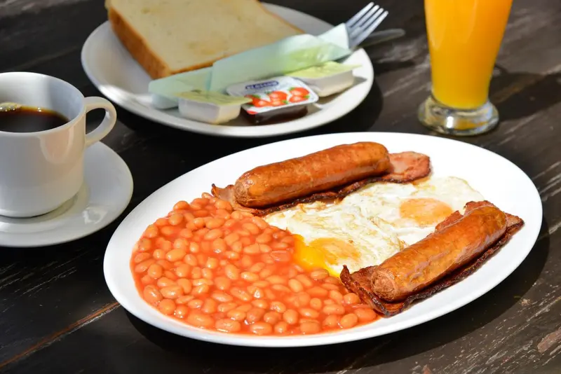 Un petit-déjeuner copieux est présenté sur une table en bois sombre.