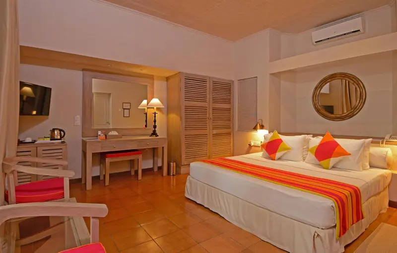 Une chambre lumineuse avec un lit double et un espace bureau.