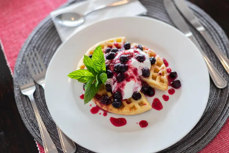 Assiette de gaufres aux myrtilles et à la crème.