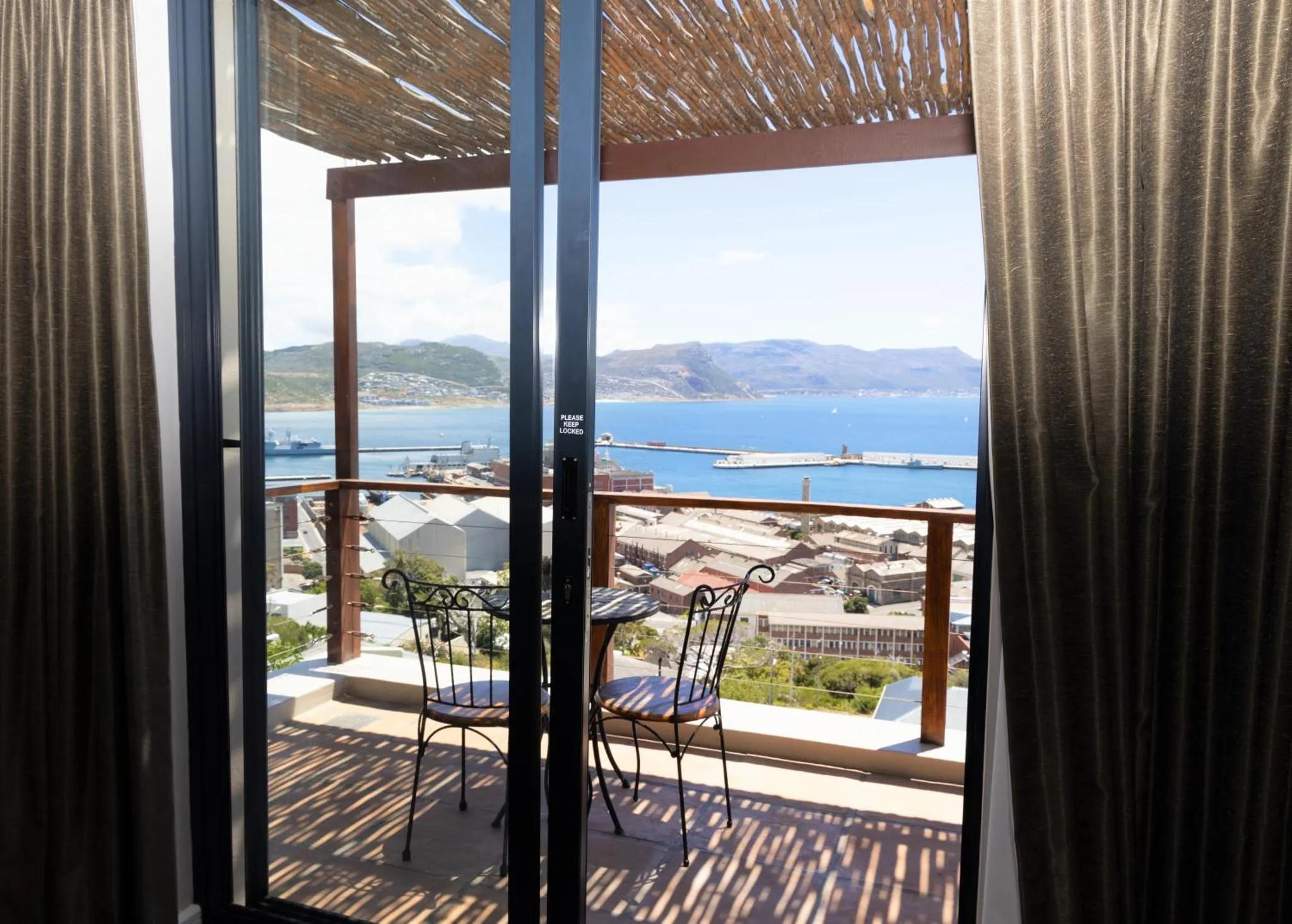 Vue sur la mer depuis une terrasse ombragée.