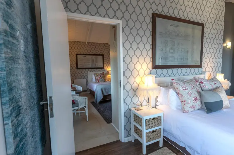 Une chambre lumineuse avec deux lits simples et un lit double.