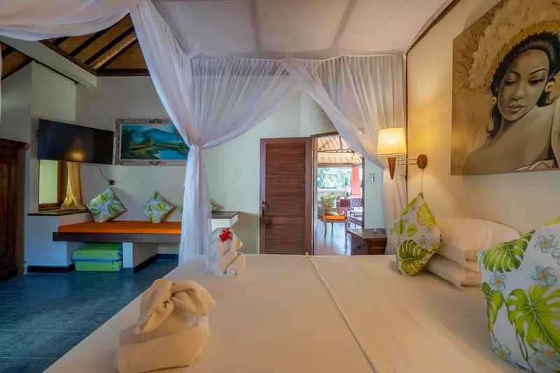 Une chambre lumineuse avec un lit à baldaquin et une décoration florale.