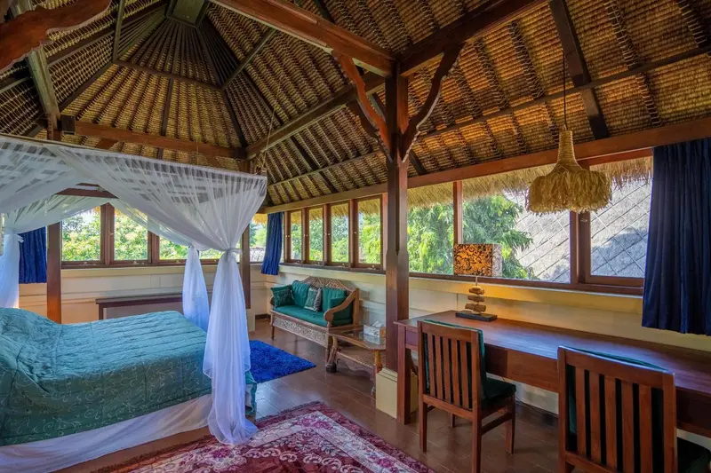 Une chambre avec un lit à baldaquin et un bureau en bois.