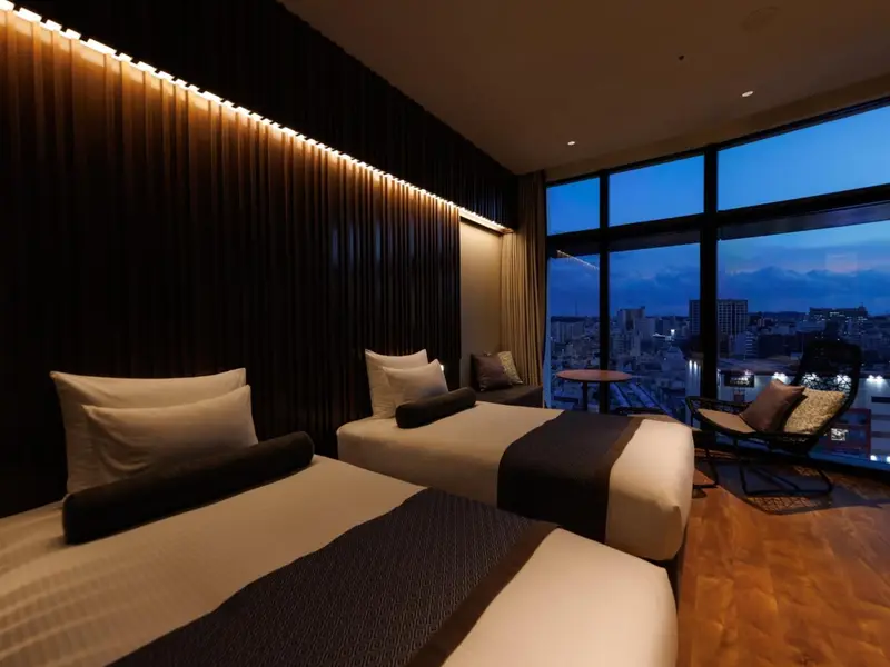 Chambre moderne avec lits jumeaux et vue sur la ville.