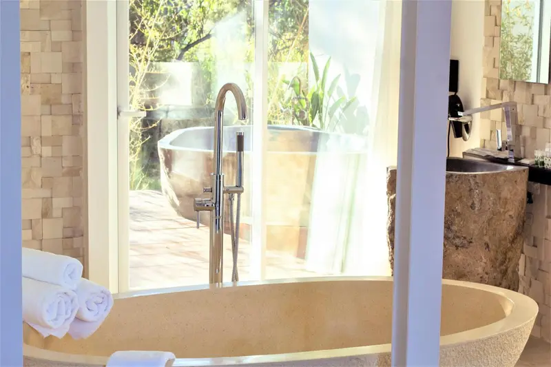 Une baignoire design se trouve dans une salle de bain lumineuse.