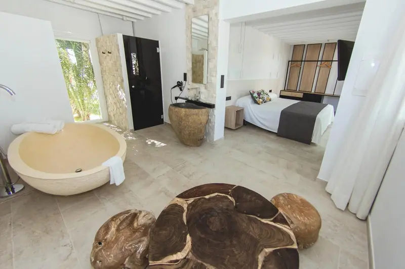 Une salle de bain spacieuse avec baignoire et vasque en pierre naturelle.