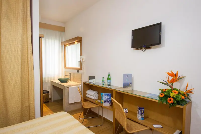Une chambre lumineuse avec un bureau et une télévision murale.