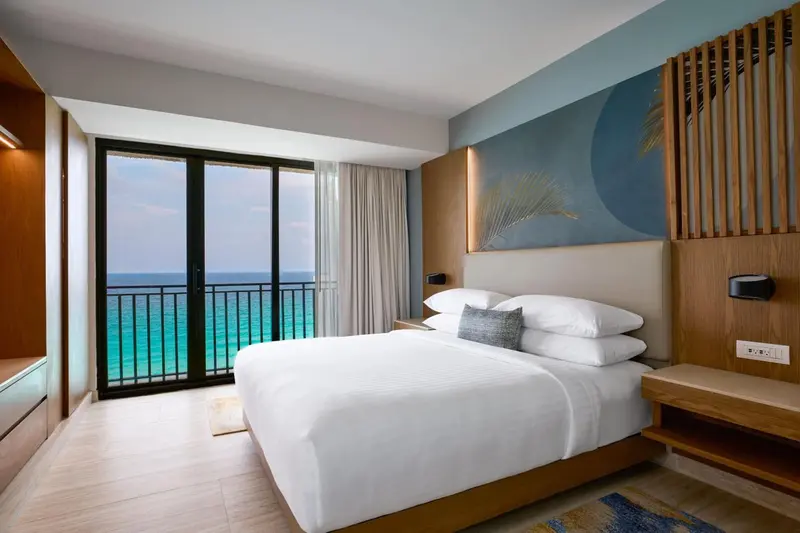 Une chambre lumineuse avec un grand lit et une vue sur la mer.