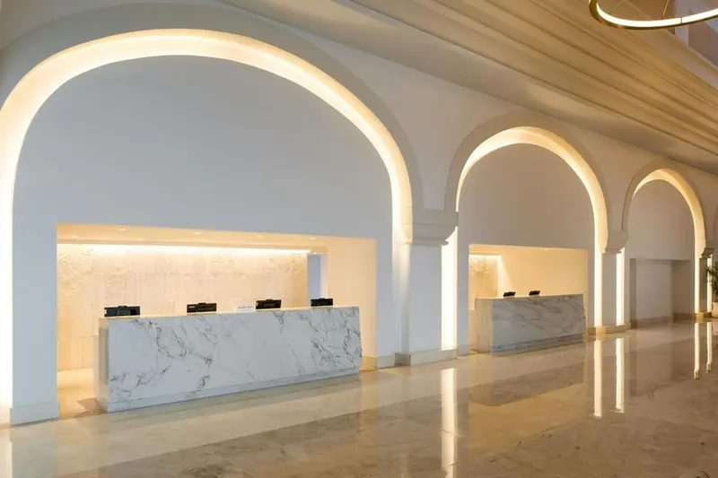 Un comptoir d'accueil lumineux dans un hall spacieux et moderne.