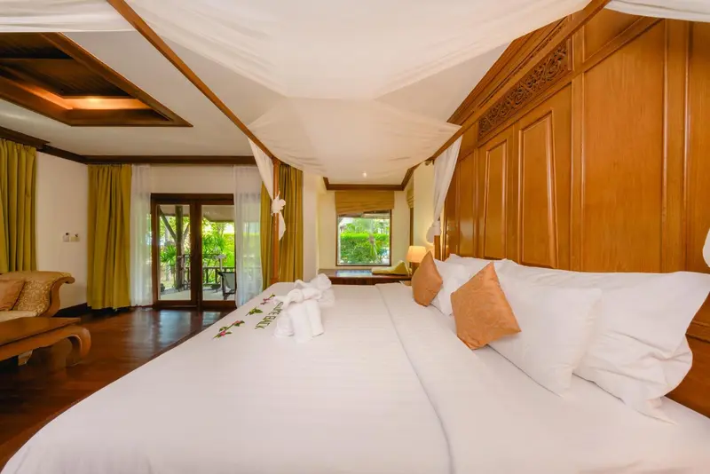 Une chambre spacieuse avec un lit à baldaquin et une décoration en bois.