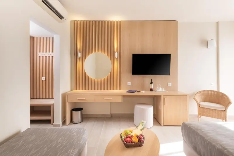 Une chambre lumineuse avec un bureau et un coin salon.