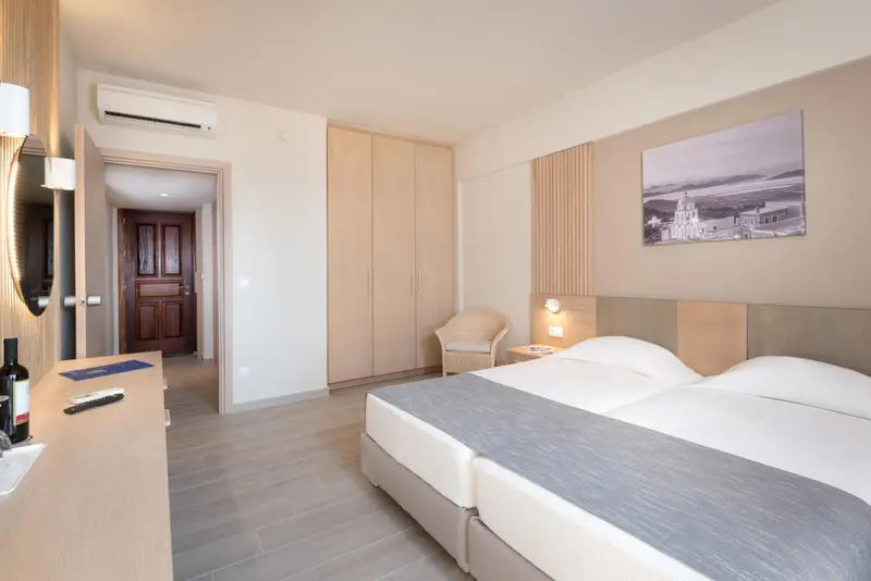 Une chambre lumineuse avec un lit double et un espace coiffure.