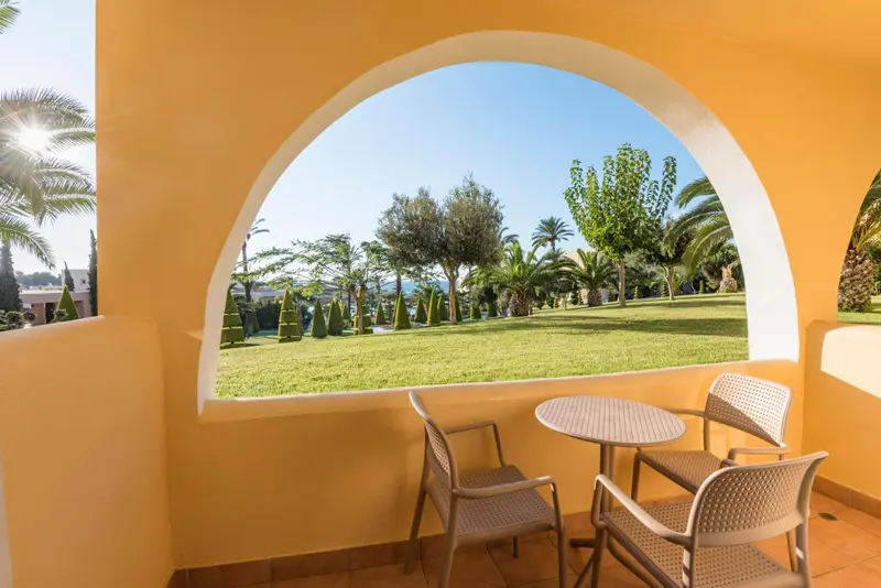 Terrasse avec mobilier de jardin donnant sur un paysage verdoyant.