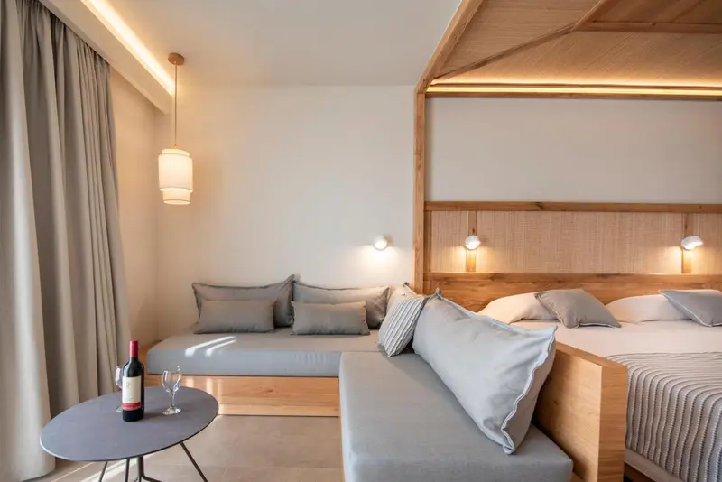 Une chambre lumineuse avec un lit et un coin salon.