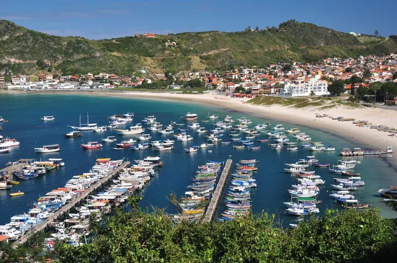 Vue aérienne d'une baie abritée avec des bateaux amarrés et une plage de sable.