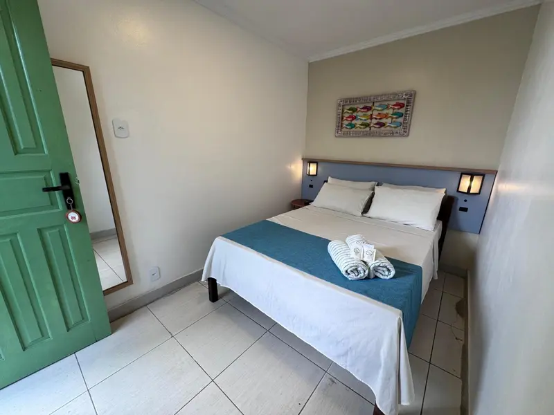 Une chambre lumineuse avec un lit double et un miroir.