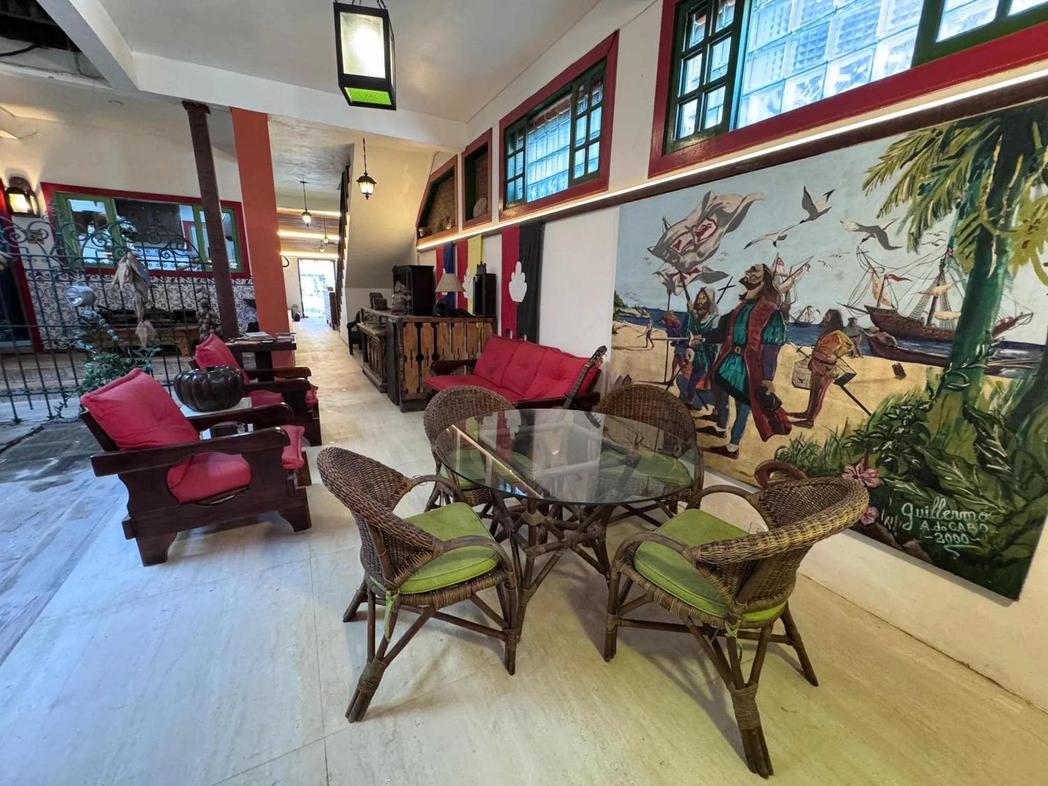 Espace de détente avec canapés et tables basses dans un décor mural tropical.