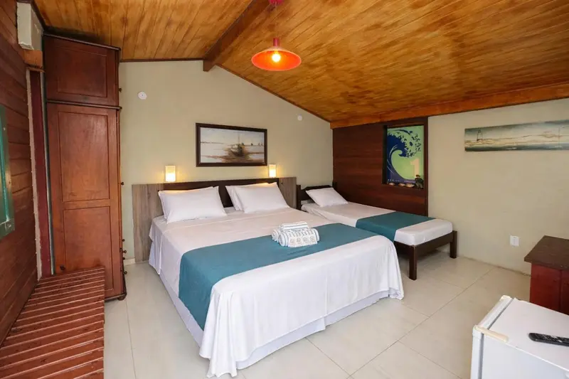 Chambre lumineuse avec deux lits simples et une décoration murale.