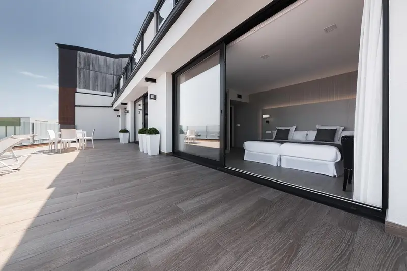 Une terrasse spacieuse donne sur un salon lumineux et moderne.