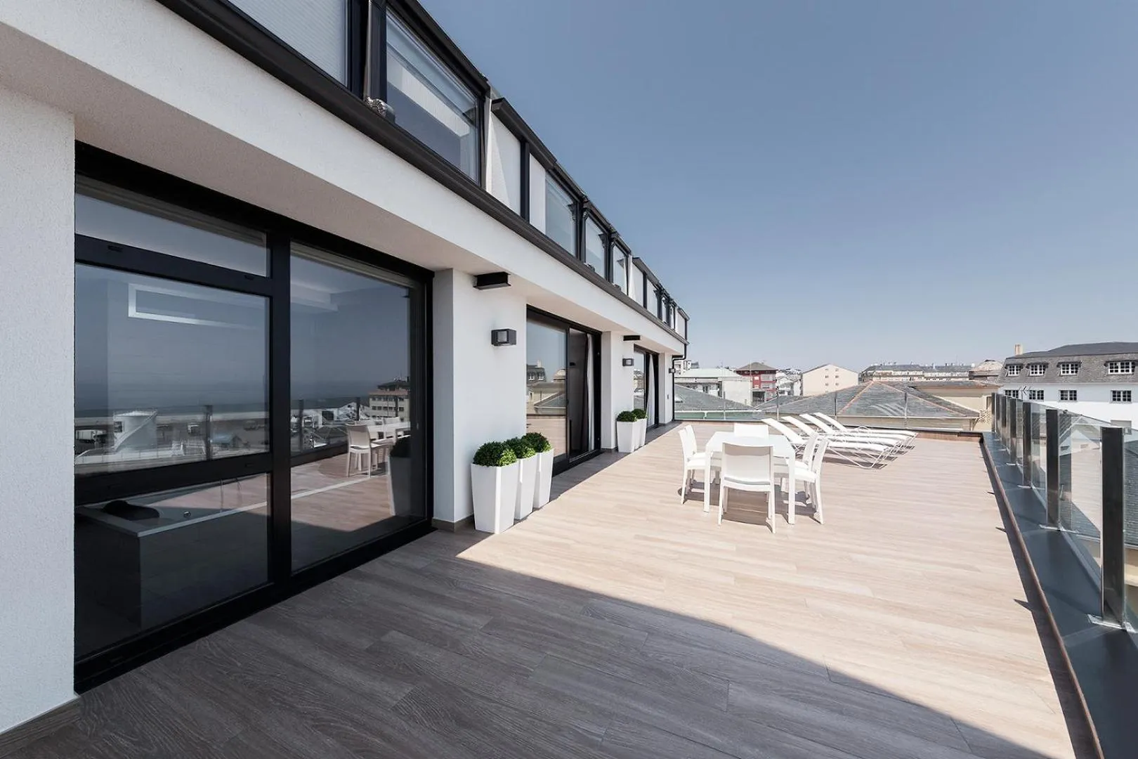 Terrasse aménagée avec mobilier de détente et vue sur la ville.