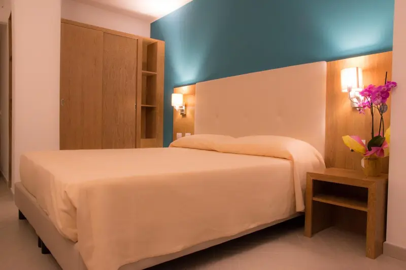 Une chambre lumineuse avec un grand lit et une décoration sobre.