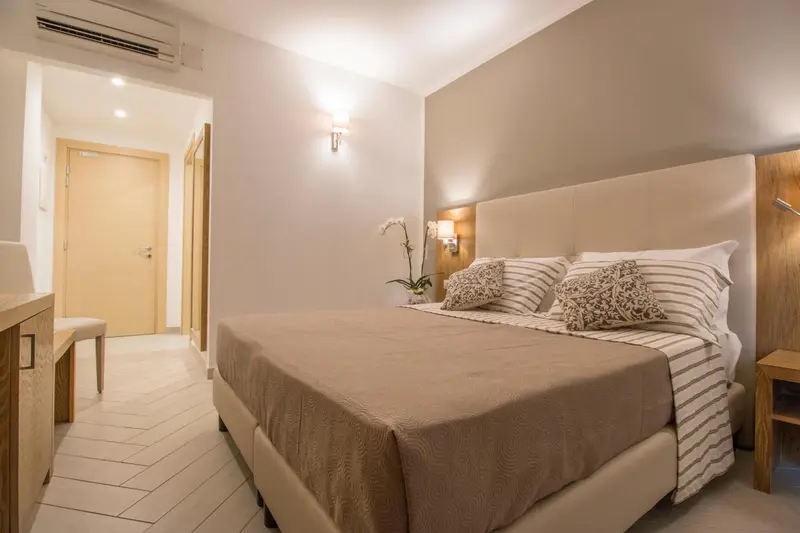 Une chambre lumineuse avec un grand lit et des meubles en bois.