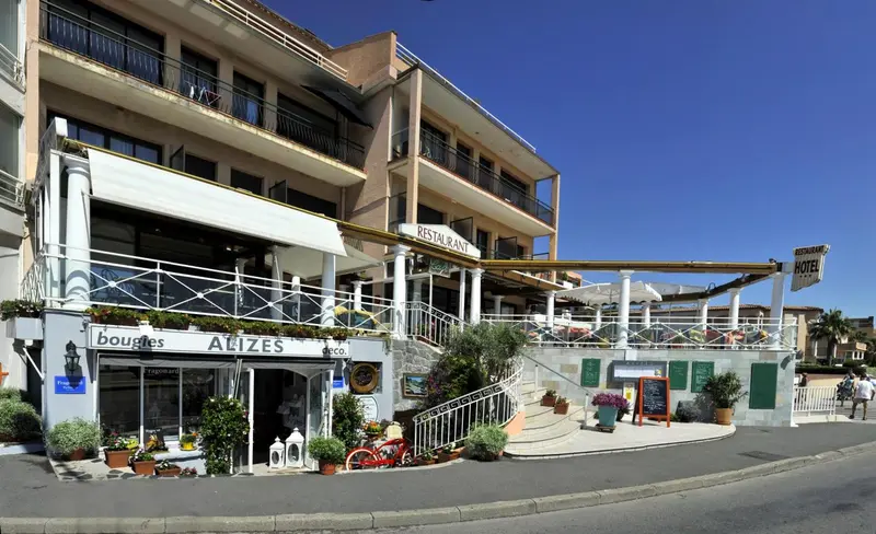 Façade d'un bâtiment avec un restaurant et des boutiques au rez-de-chaussée.