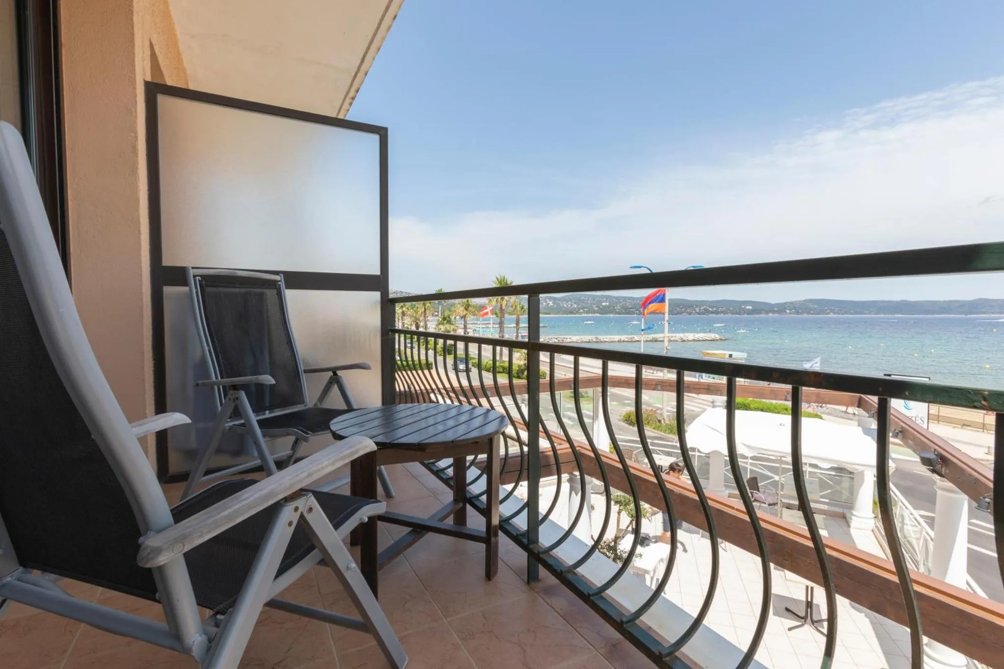 Terrasse avec mobilier de jardin et vue sur la mer.