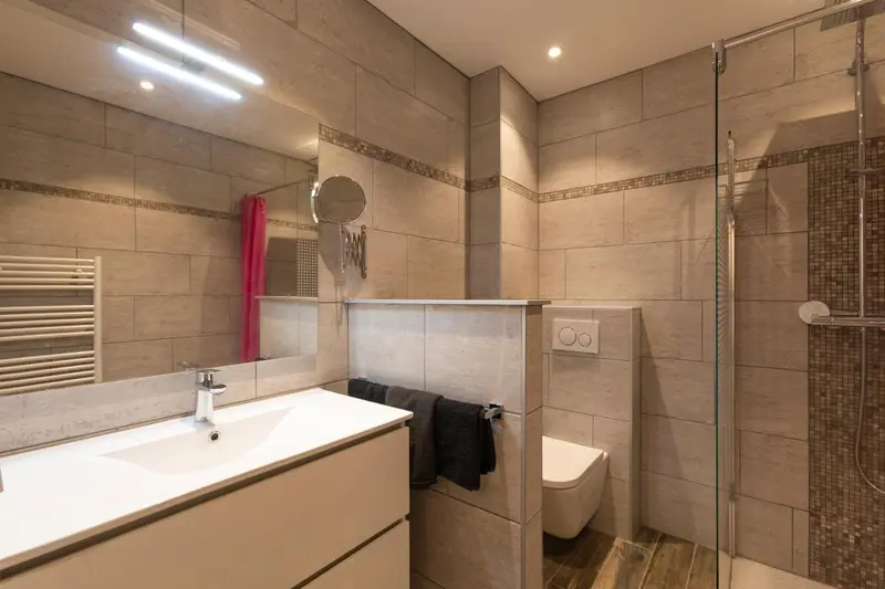 Une salle de bain moderne avec douche à l'italienne et carrelage beige.