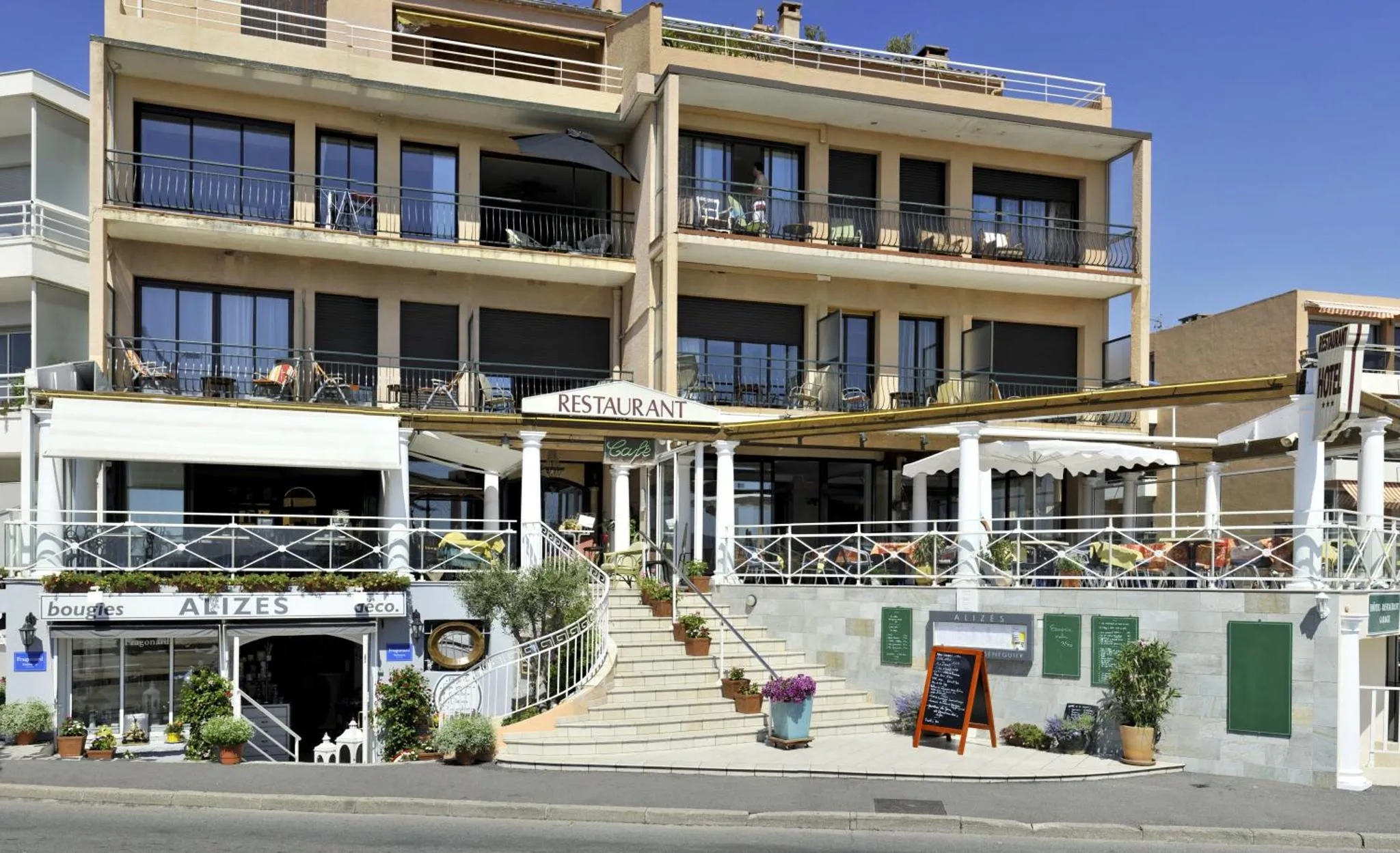 Façade d'un bâtiment avec un restaurant en rez-de-chaussée et des balcons à étages.