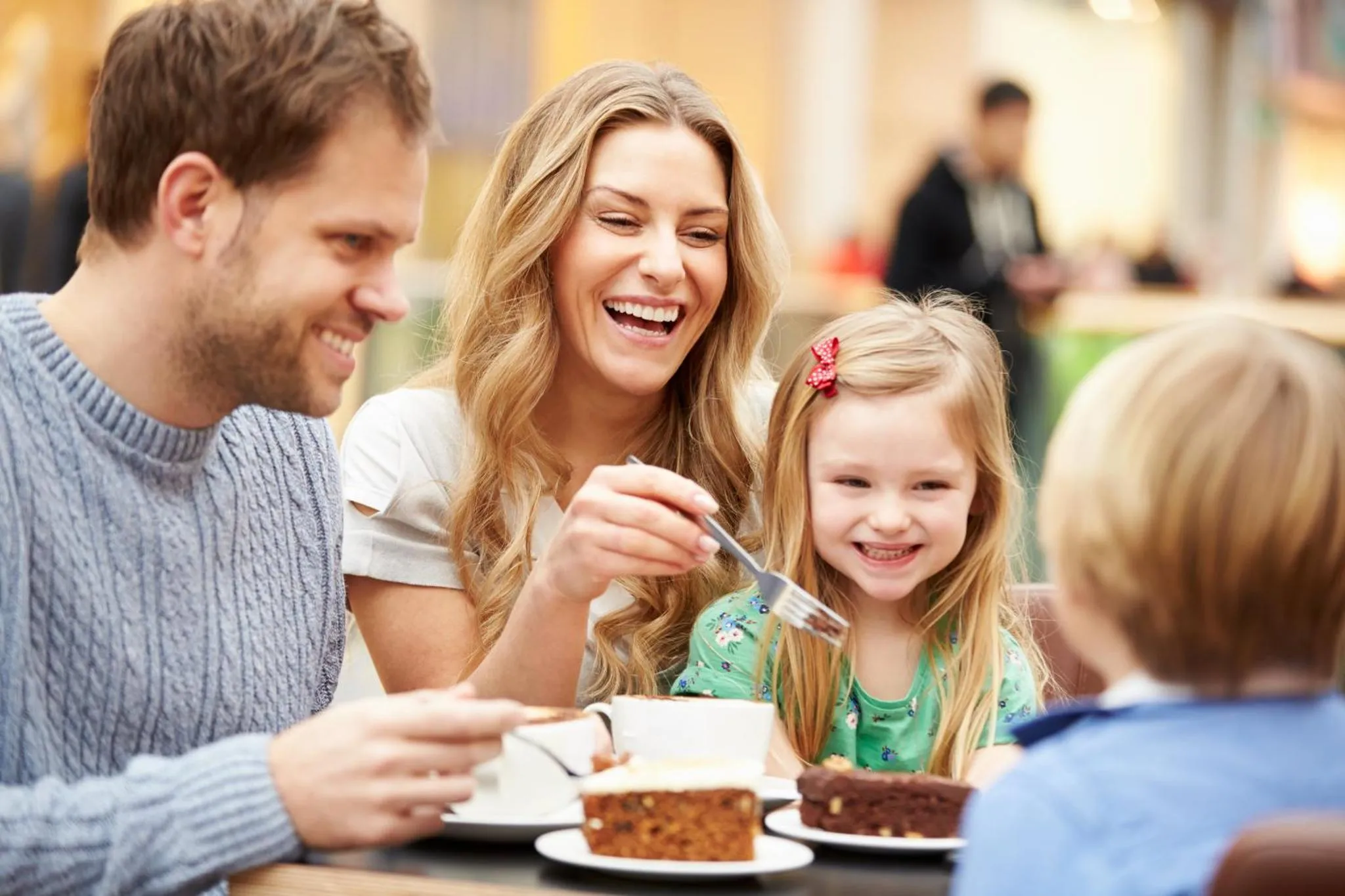Une famille souriante partage un repas à table.