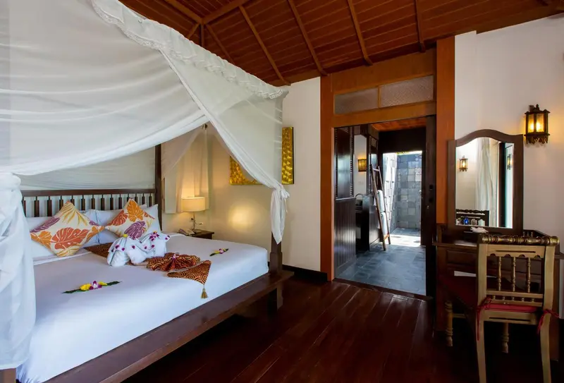 Une chambre avec un grand lit à baldaquin et un accès à une salle de bain.