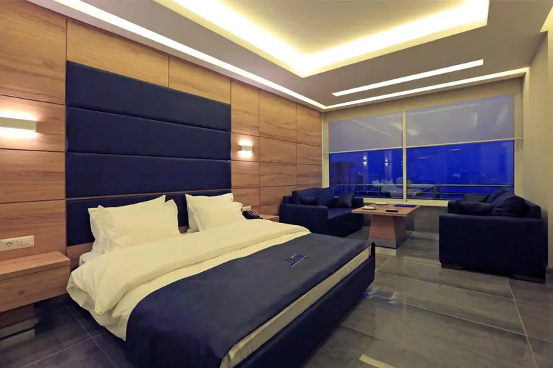 Une chambre moderne avec un grand lit et un coin salon.