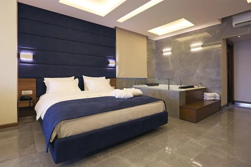 Une chambre moderne avec un grand lit et une baignoire jacuzzi.