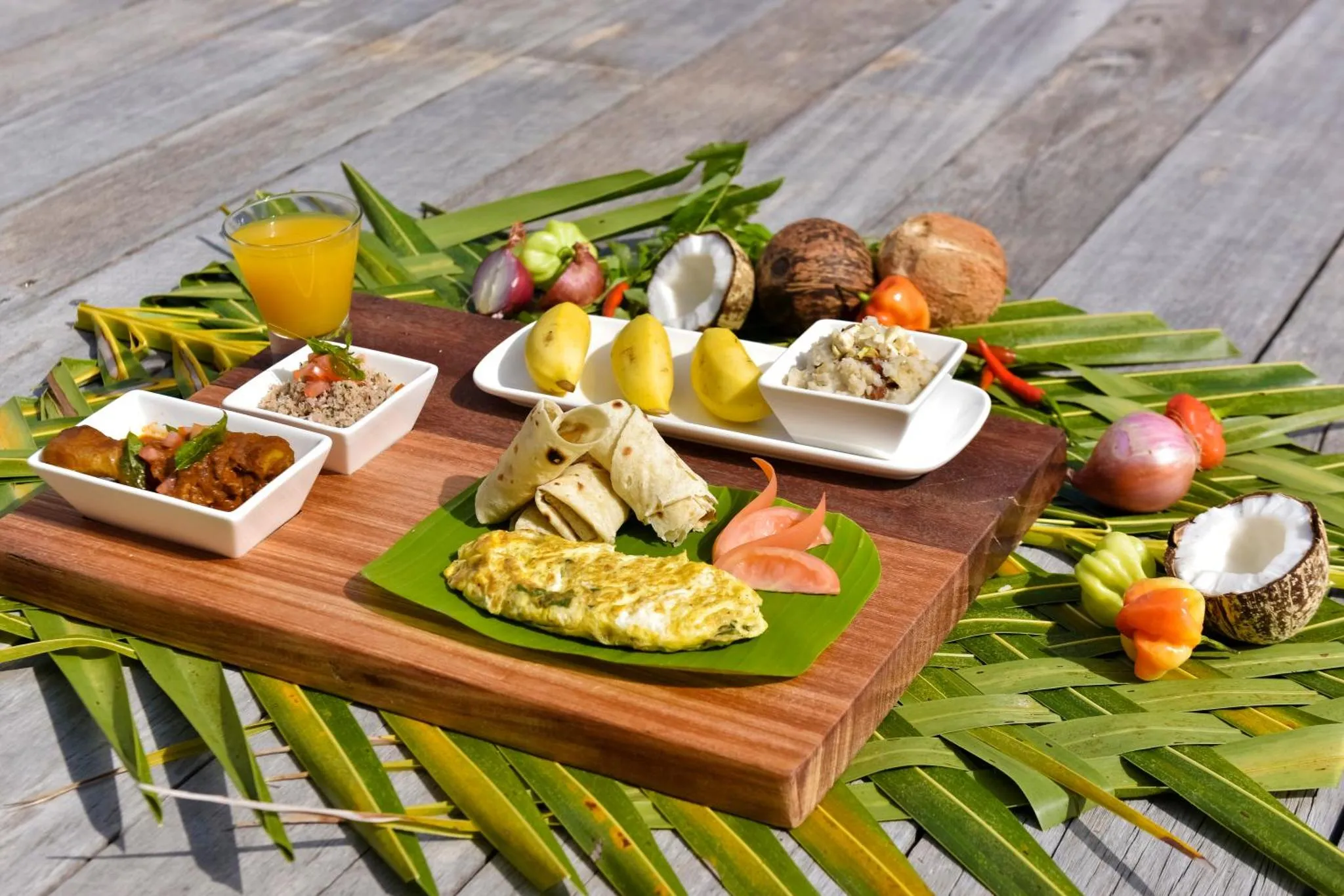 Assortiment de plats exotiques présentés sur une planche en bois.