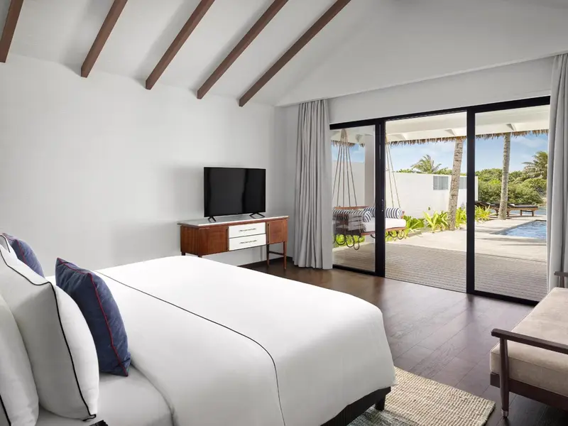 Une chambre lumineuse avec un grand lit et un accès direct à une terrasse avec vue sur la piscine.