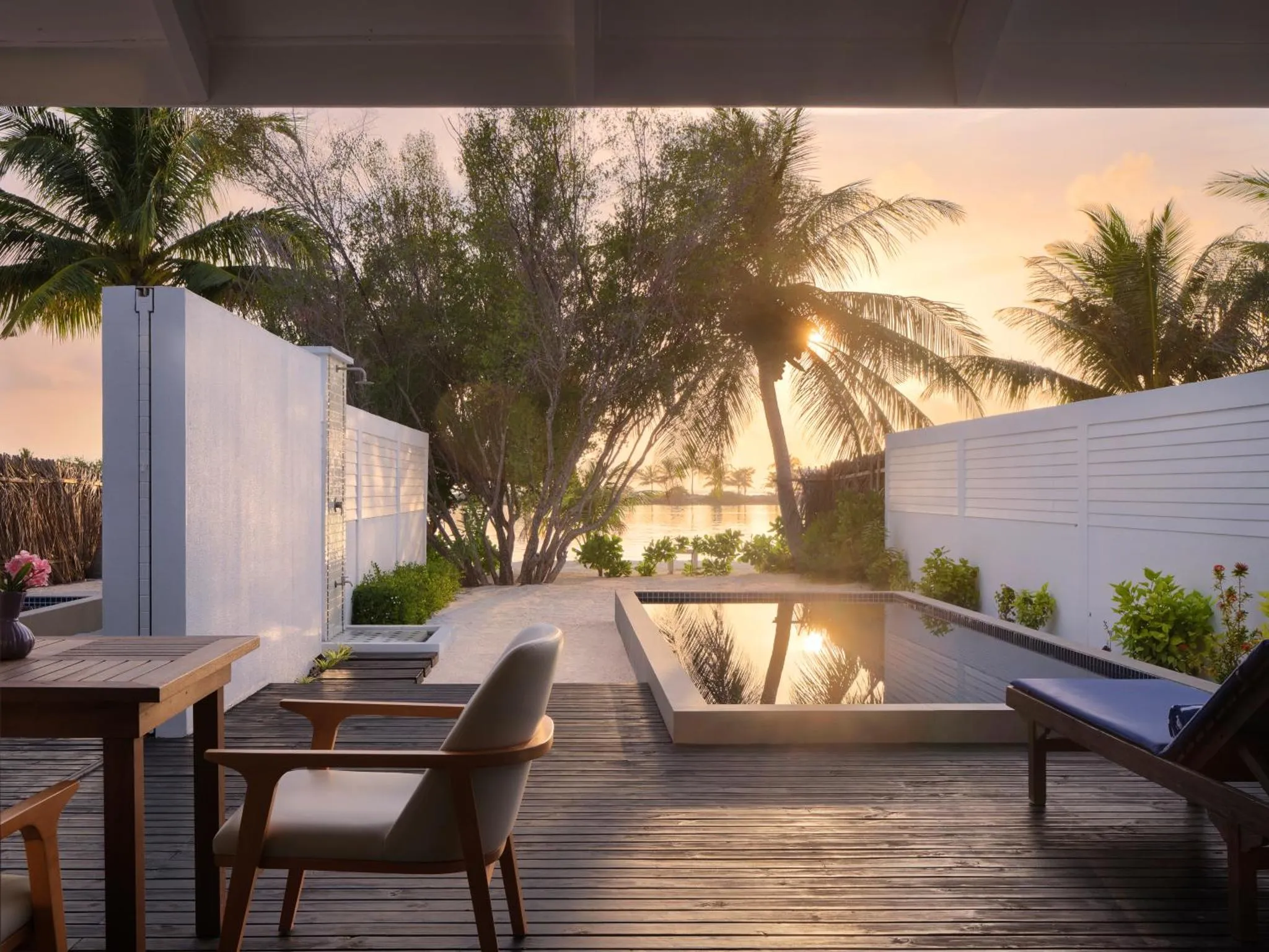 Terrasse en bois avec mobilier et petite piscine privative face à la mer.