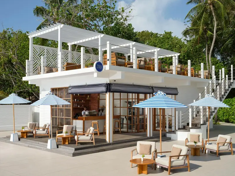 Terrasse ombragée avec mobilier de détente et bar en plein air.