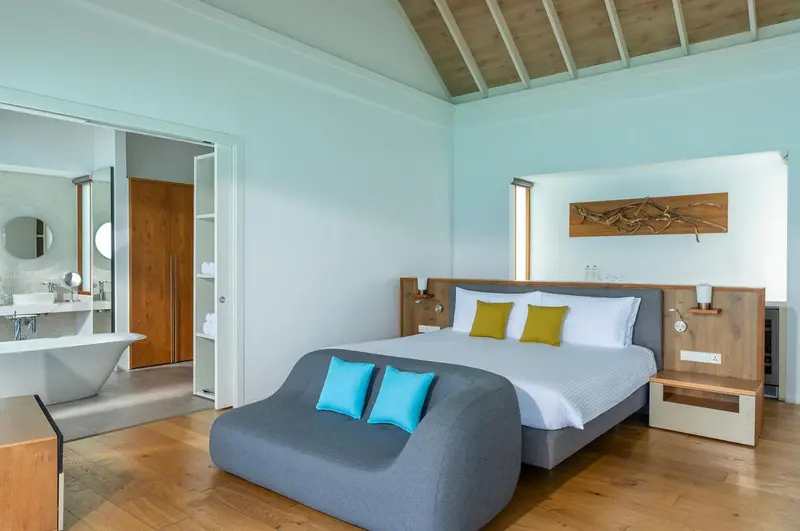Une chambre lumineuse avec un lit double et un espace détente.
